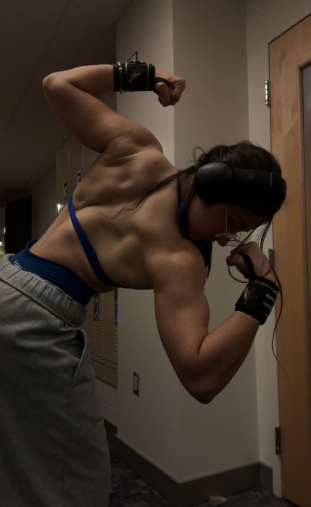 The coach is showing her back muscle.